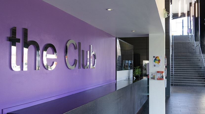 Entrance of the Club gym with a sign on the purple wall that reads 'The Club'