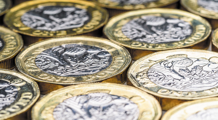 A selection of pound coins all lying flat.