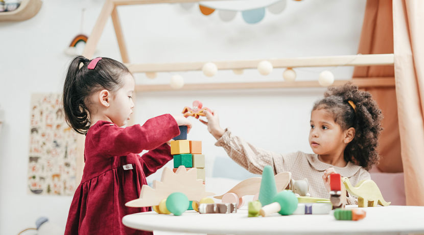 Two young children playing with blocks in a nursery.