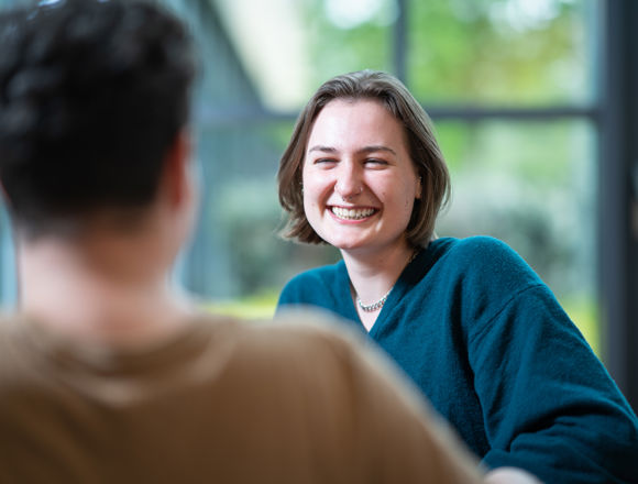 Girl and boy laughing together at an Edinburgh College campus.