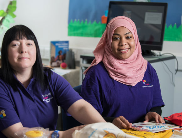Childcare students looking at children's books in a classroom.
