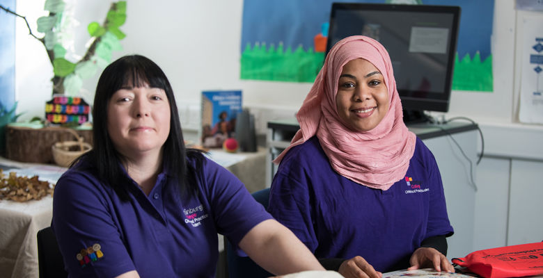 Childcare students looking at children's books in a classroom.