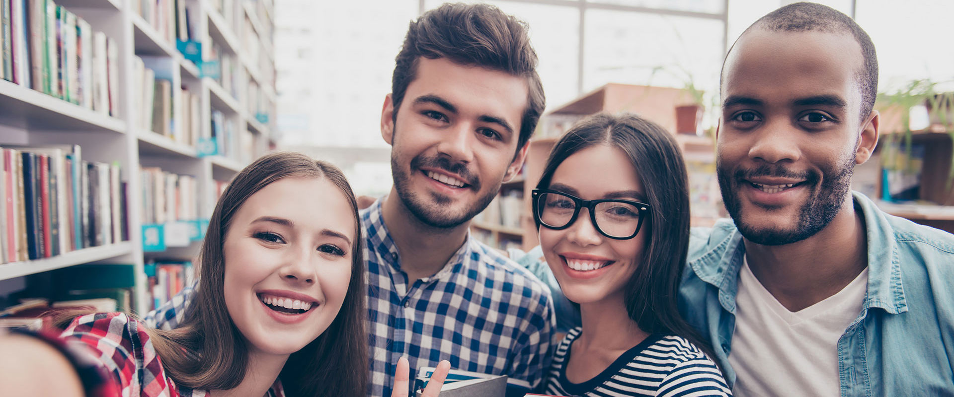 Selfie of students smiling in the library.