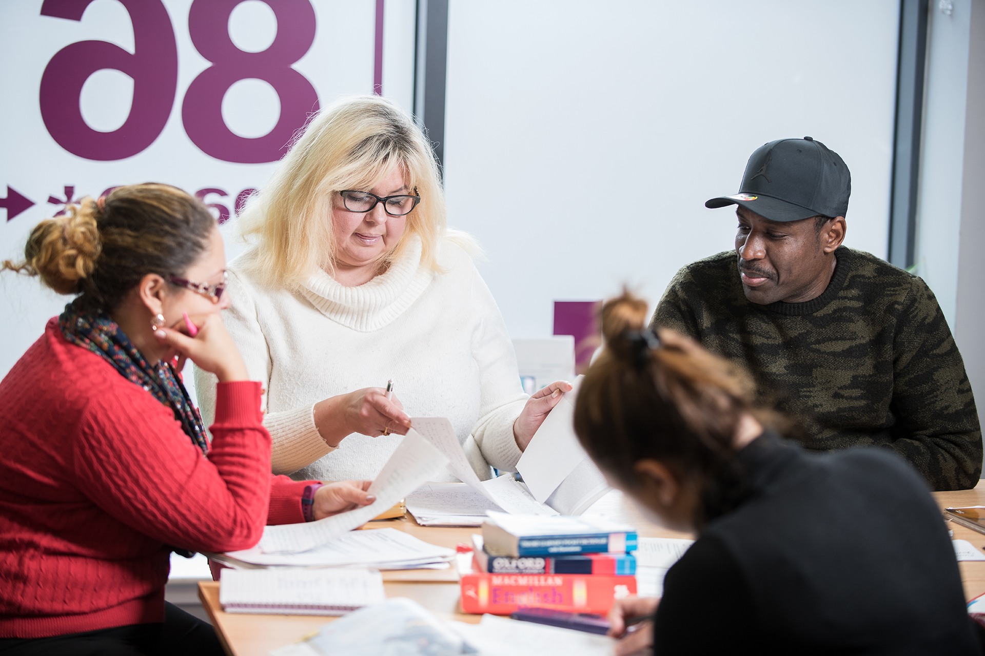 ESOL students working together at a desk in a classroom.