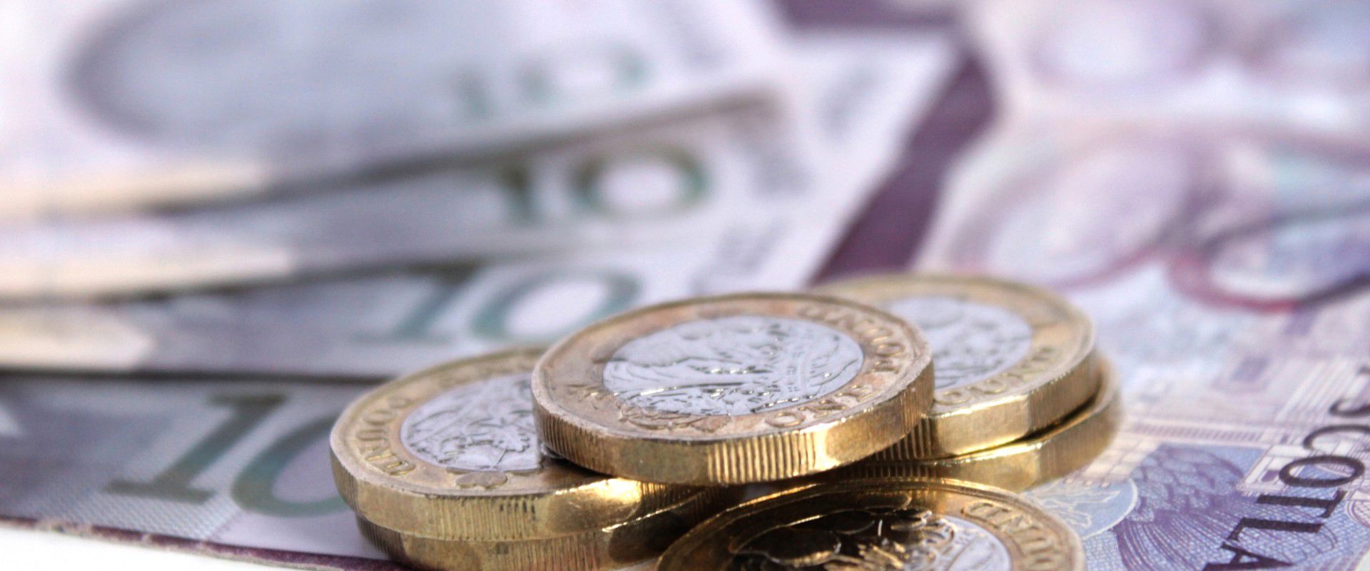 Pound coins on top of bank notes.
