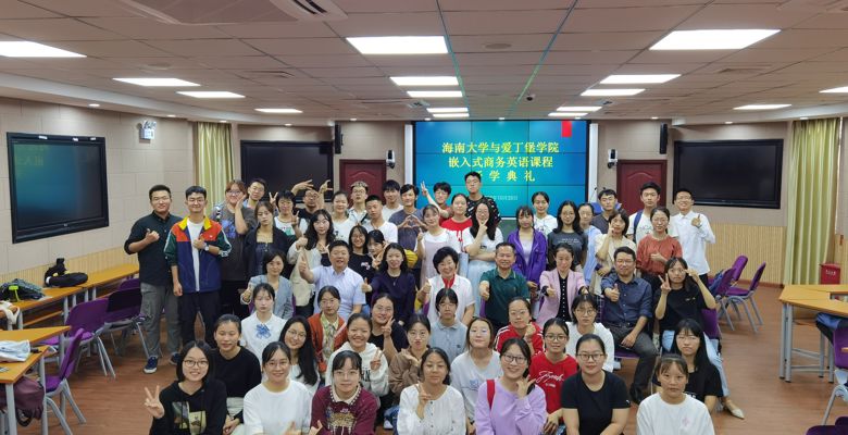 A diverse group of students pose together in a classroom, celebrating the start of a new business English course.