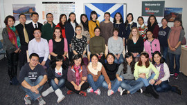 Group of exchange students and representatives from China posing for a group photo.