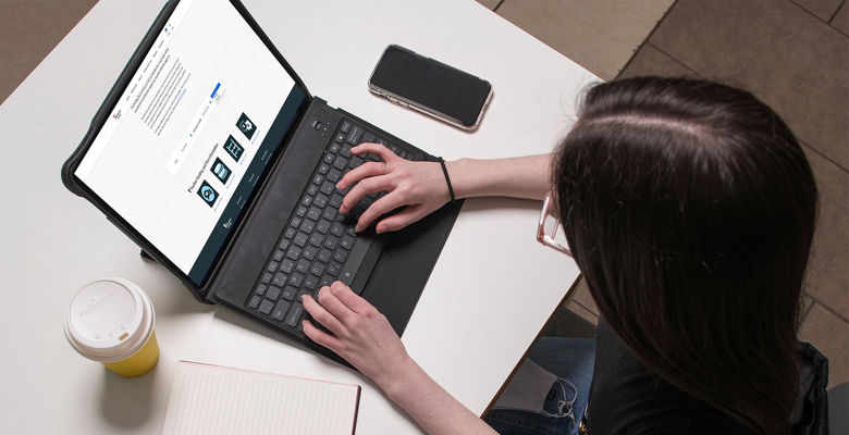 Student from above looking at the funding tool page on their laptop.