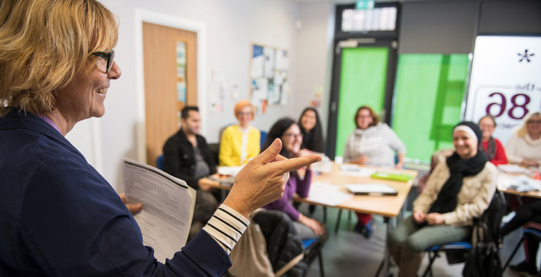 ESOL lecturer teaching in front of a classroom of students.