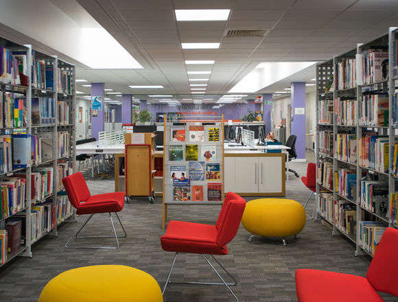 Red and yellow seats spread across the floor with bookshelves on either side.