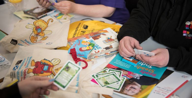 Children's books and games scattered over a desk. 