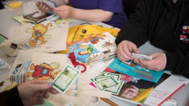 Children's books and games scattered over a desk.