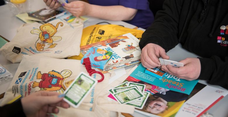 Children's books and games scattered over a desk.