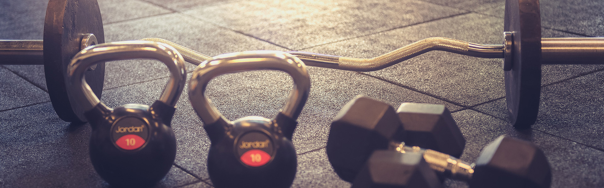 Weights and kettle bells on the floor of a gym.