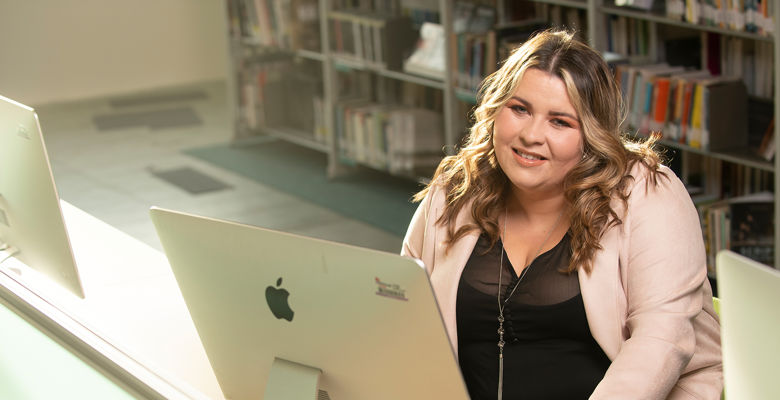 Student working at a desktop computer in the library.
