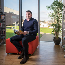 Student sitting in the library reading a book.
