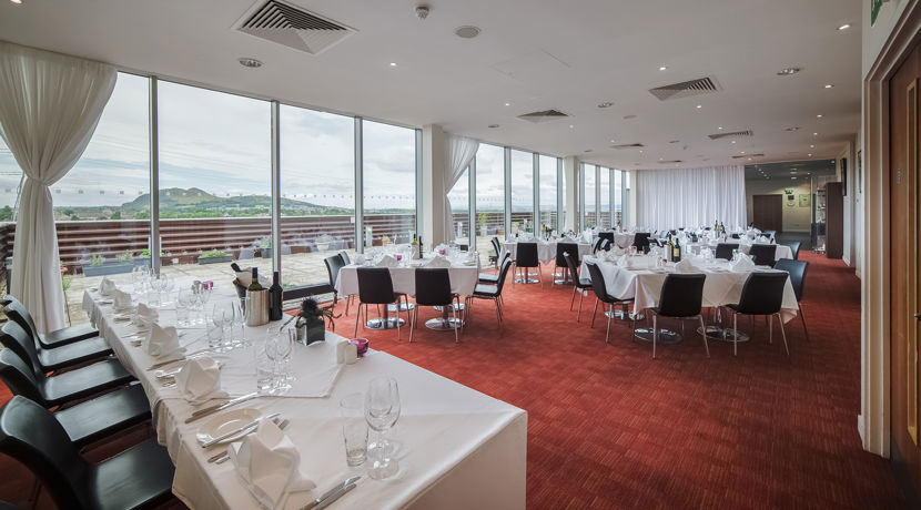 Restaurant at Edinburgh College set up for an event, with white table clothes, glass wear and cutlery on tables.