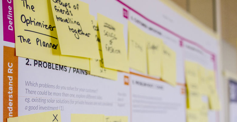 Post-it notes mapped out on a larger piece of paper to make a plan.