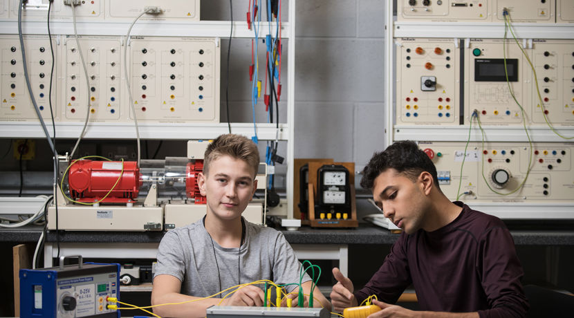 Two electrical engineering students working with cables.