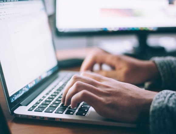 Person typing on a laptop.