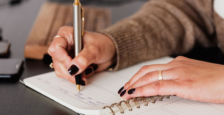 Close up of someone writing in their diary.